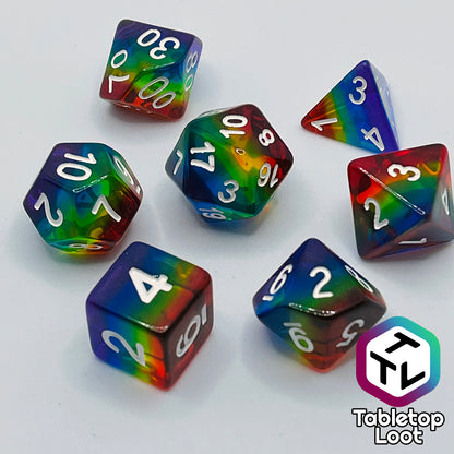 The Pride 7 piece dice set from Tabletop Loot with stripes of translucent colors in rainbow order and white numbering.