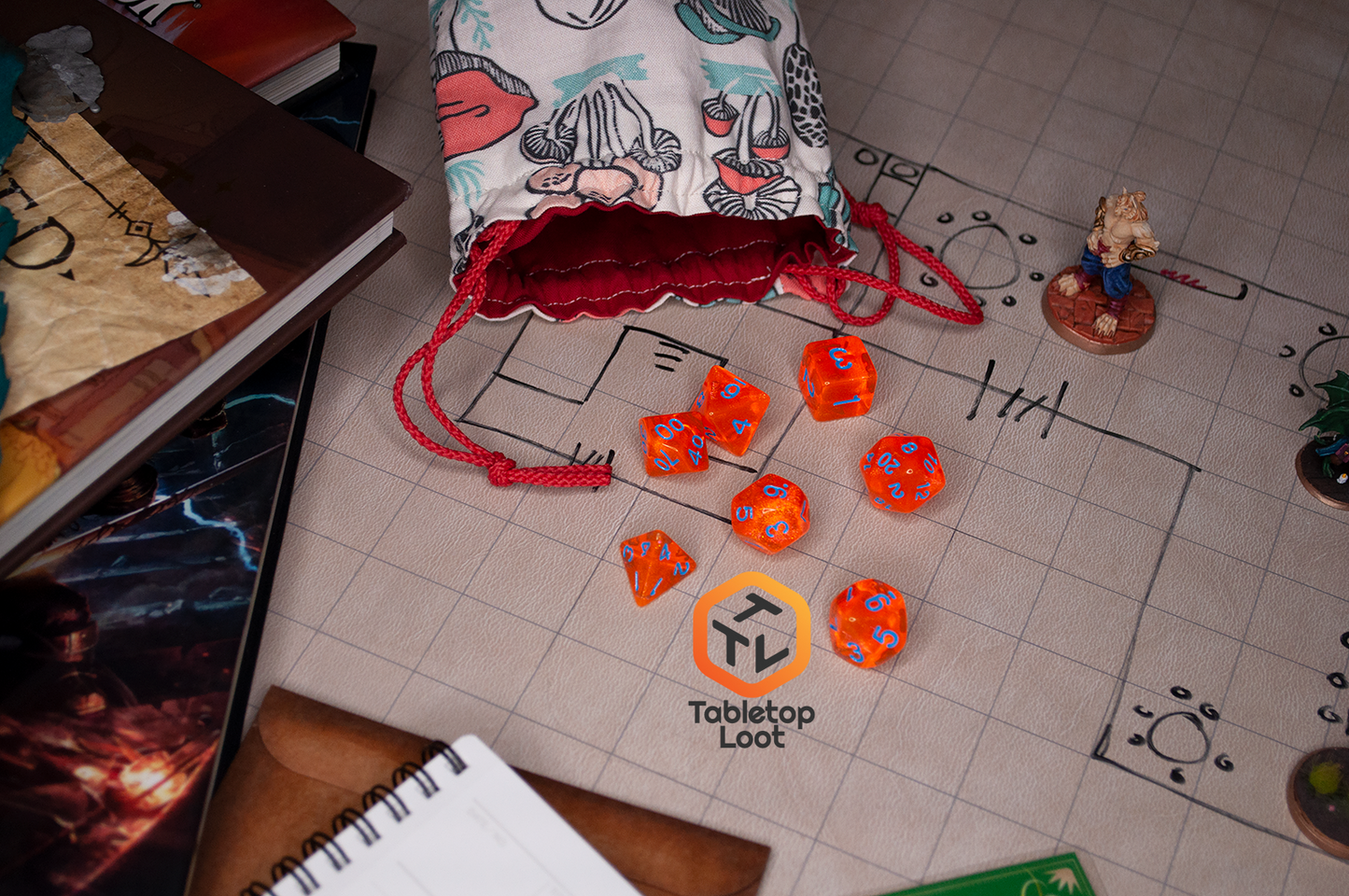 The Radioactive Orange 7 piece dice set from Tabletop Loot with sparkly orange resin and bright blue numbering.