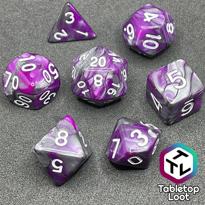 The Purple Knight 7 piece dice set from Tabletop Loot with swirls of purple and pearlescent grey and white numbering.