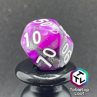 A close up of the percentile die from the Purple Knight 7 piece dice set from Tabletop Loot with swirls of purple and pearlescent grey and white numbering.