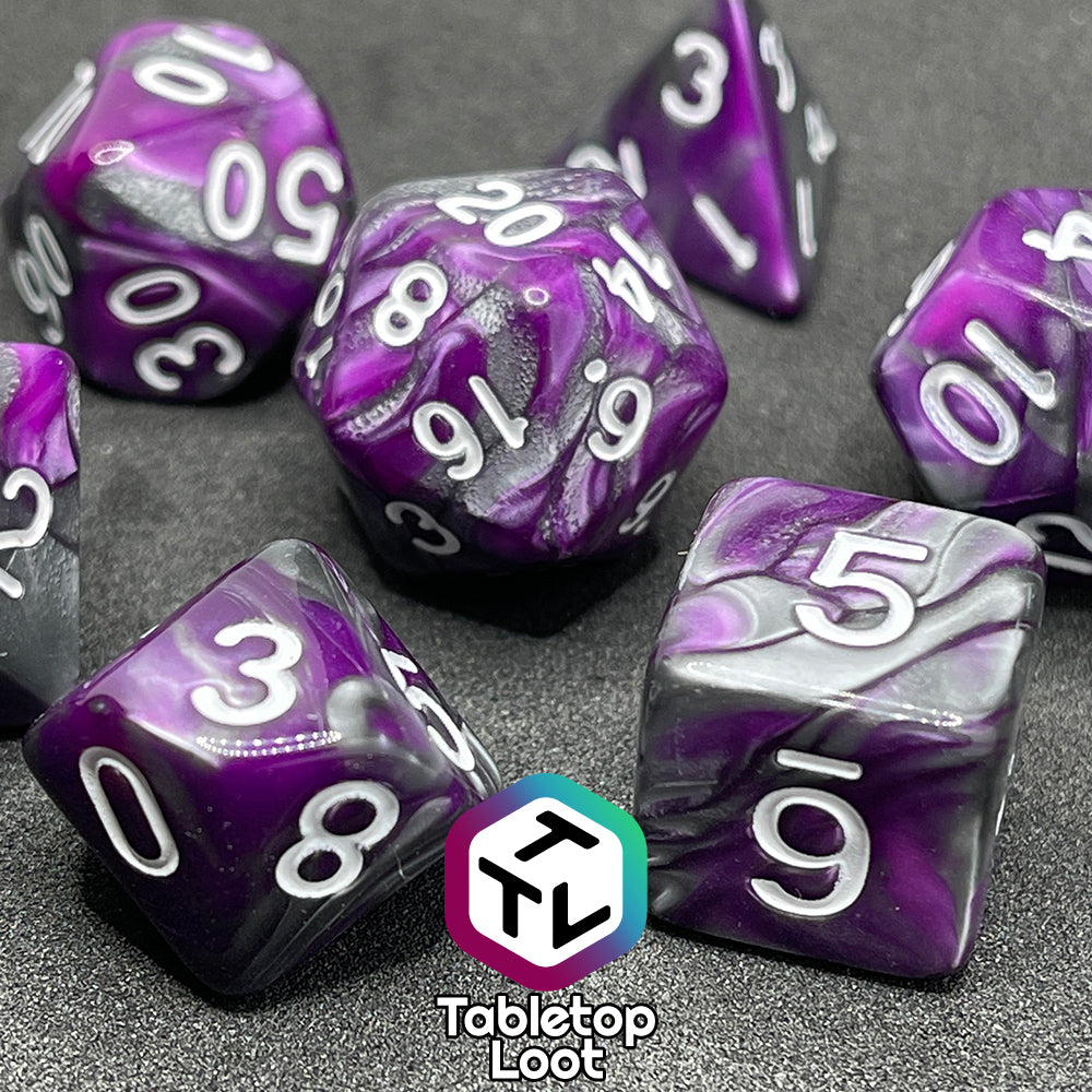 A close up of the Purple Knight 7 piece dice set from Tabletop Loot with swirls of purple and pearlescent grey and white numbering.