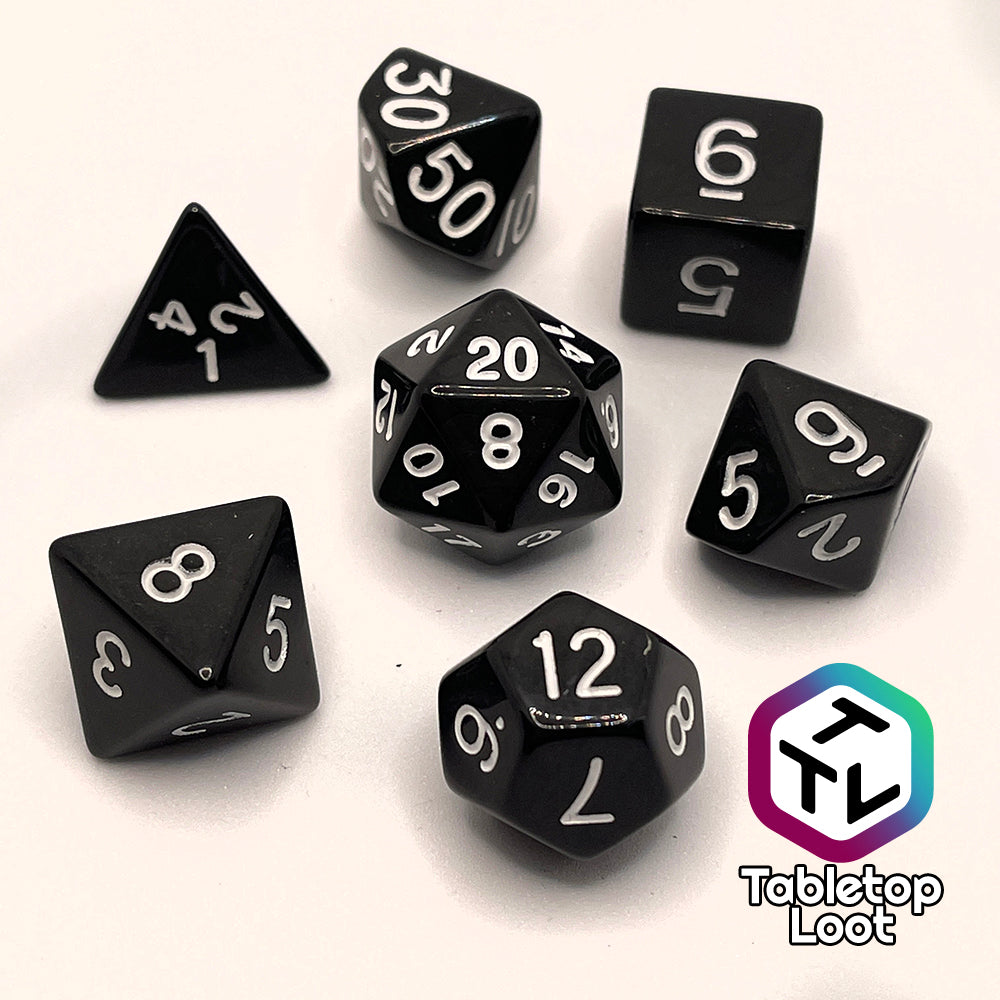The Ravenous Void 7 piece dice set; solid black with white numbering.