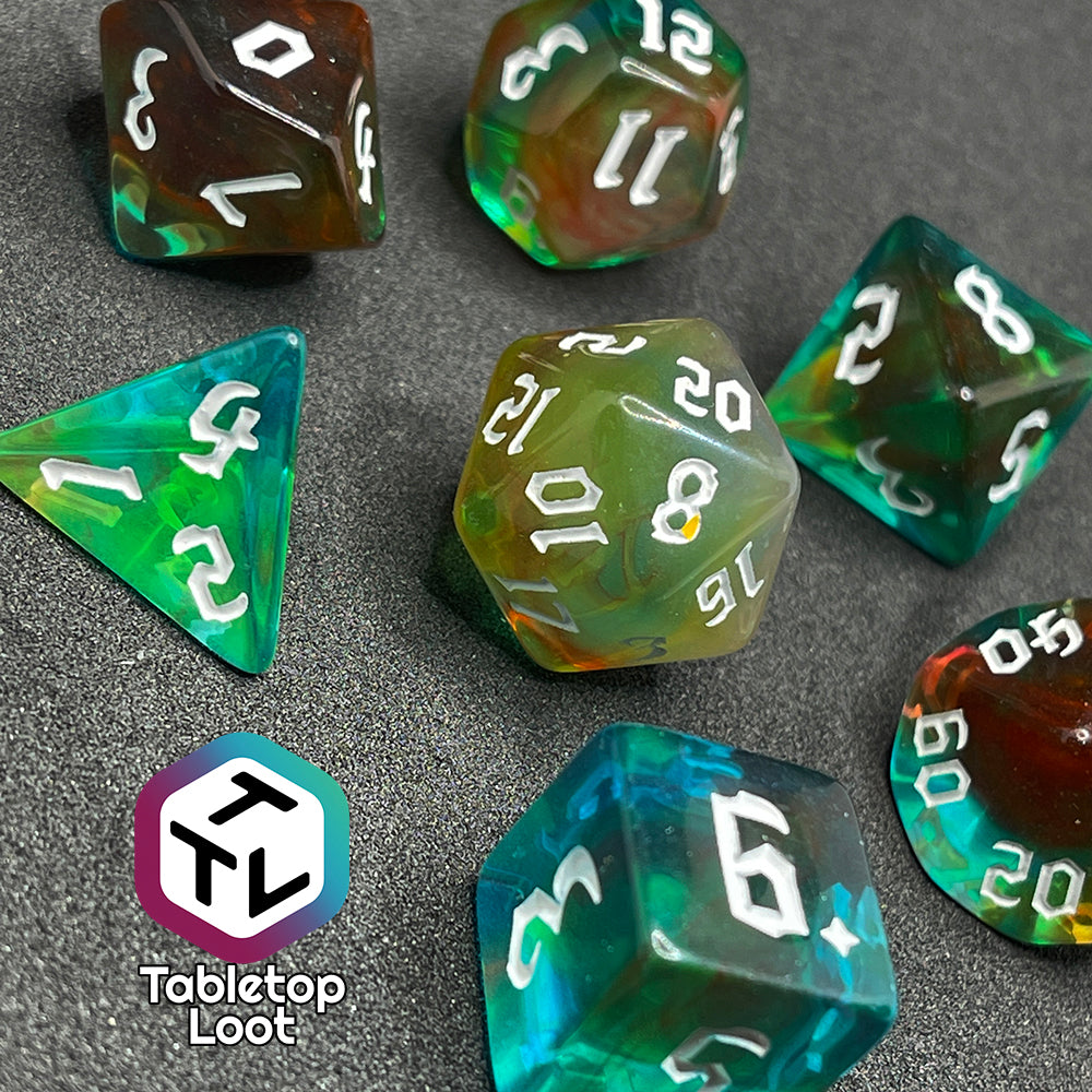 Set of seven semi-translucent dice swirling with blues, greens, reds, & yellows with white numbers.