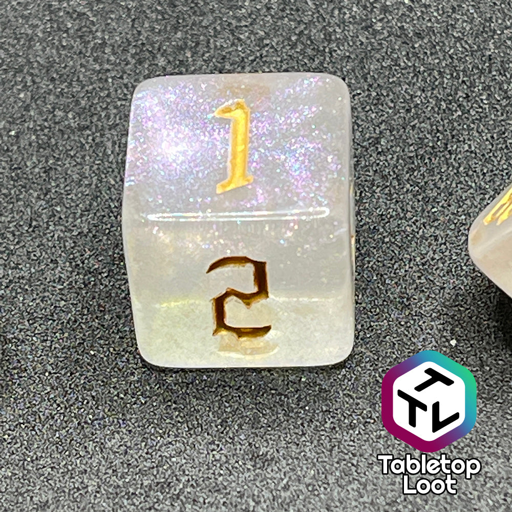 A close up of the D6 from the Revivify 7 piece dice set from Tabletop Loot; semi-translucent dice with iridescent micro glitter and gold gothic numbering.