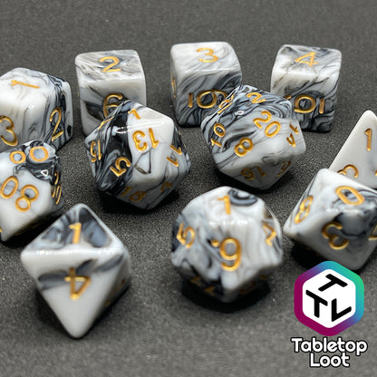 A close up of the Rolling Thunder 11 piece dice set from Tabletop Loot, black and white marbled patterns and gold numbering.
