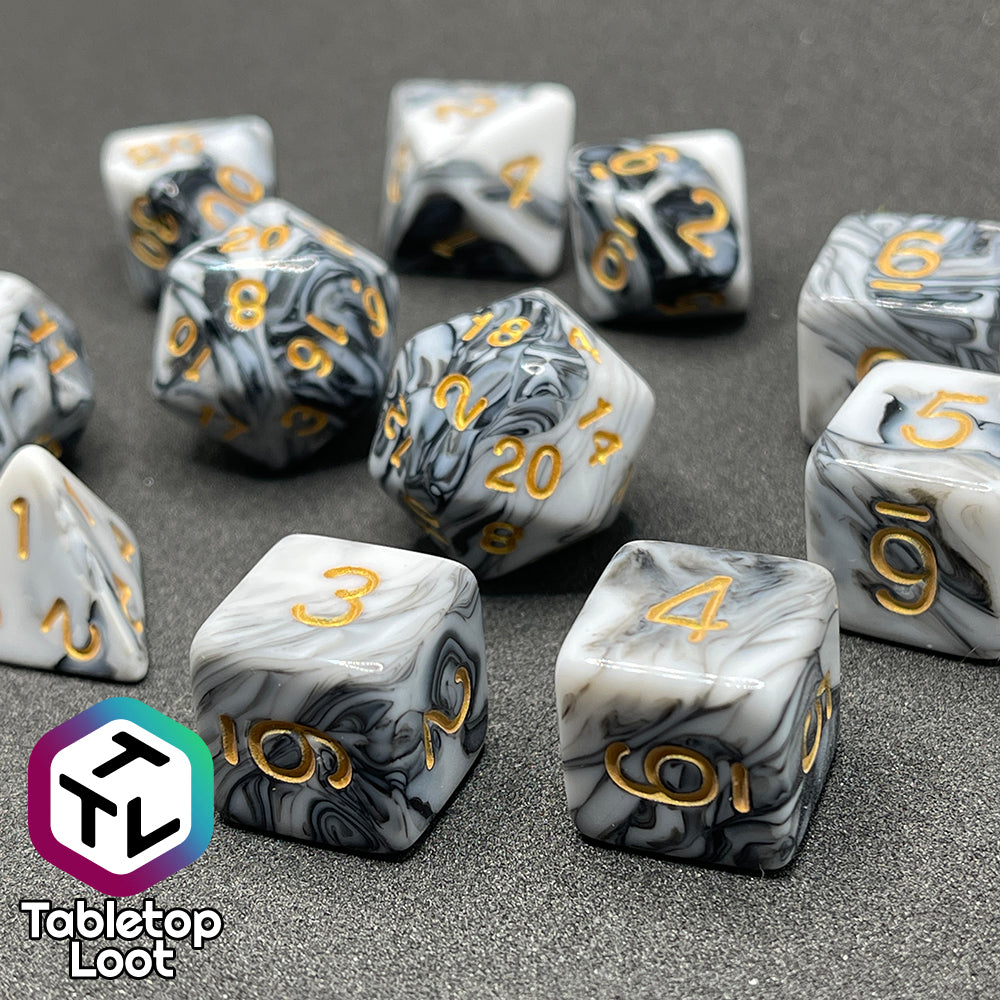 A close up of the Rolling Thunder 11 piece dice set from Tabletop Loot, black and white marbled patterns and gold numbering.
