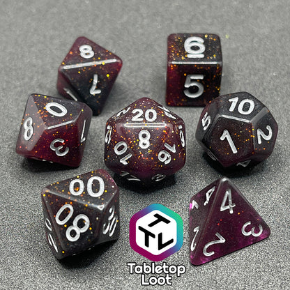 The Rosavalda 7 piece dice set from Tabletop Loot, ultra dark purple dice with golden glitter and white numbering.