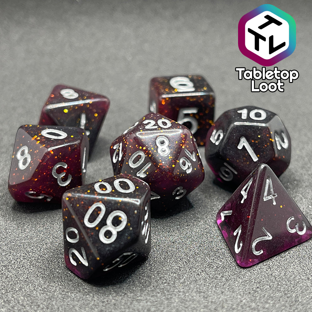 A close up of the Rosavalda 7 piece dice set from Tabletop Loot, ultra dark purple dice with golden glitter and white numbering.