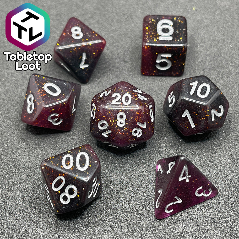 The Rosavalda 7 piece dice set from Tabletop Loot, ultra dark purple dice with golden glitter and white numbering.