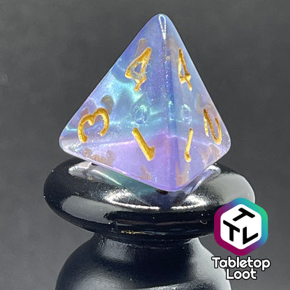 A close up of the D4 from the Shape Water 7 piece dice set from Tabletop Loot with swirls of glittery purple and blue resin and gold numbering.