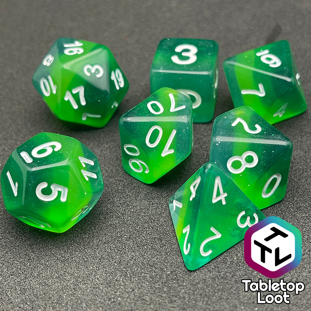 The Shillelagh 7 piece dice set from Tabletop Loot with layers of green to blue and white numbers.