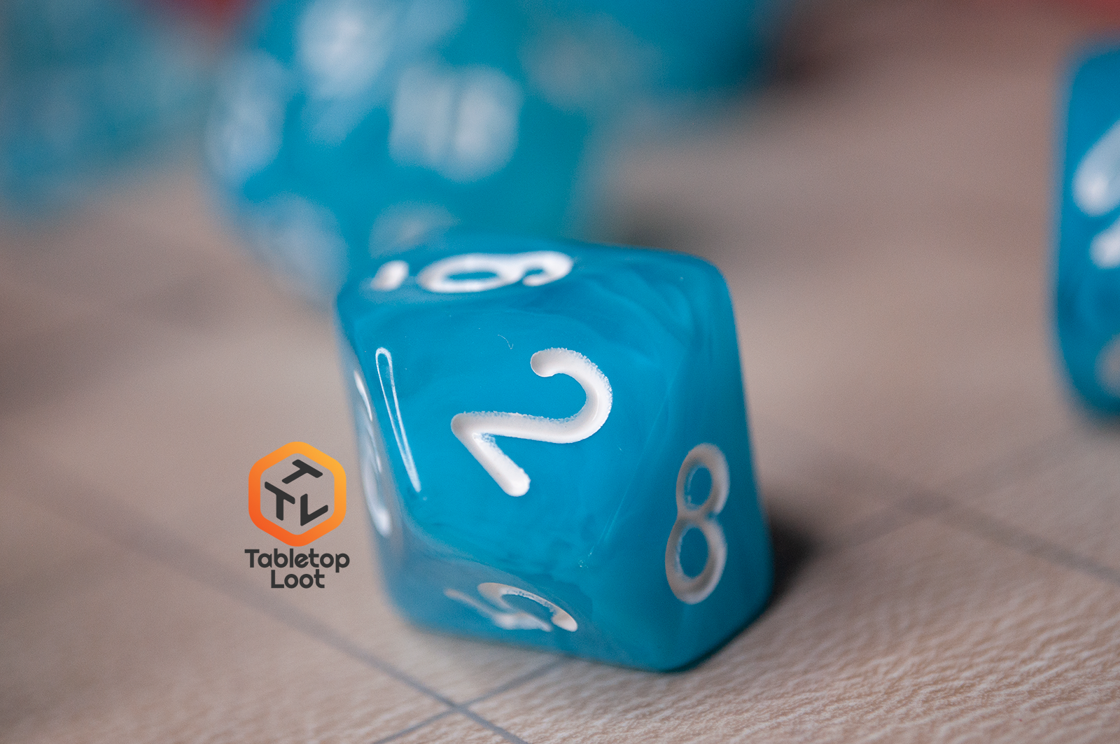 A closeup of the D10 from the Sky Blue 7 piece dice set from Tabletop Loot with blue and white swirls in clear resin and white numbering.