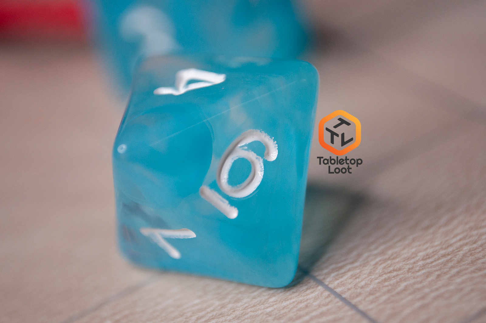 A close up of the D8 from the Sky Blue 7 piece dice set from Tabletop Loot with blue and white swirls in clear resin and white numbering.