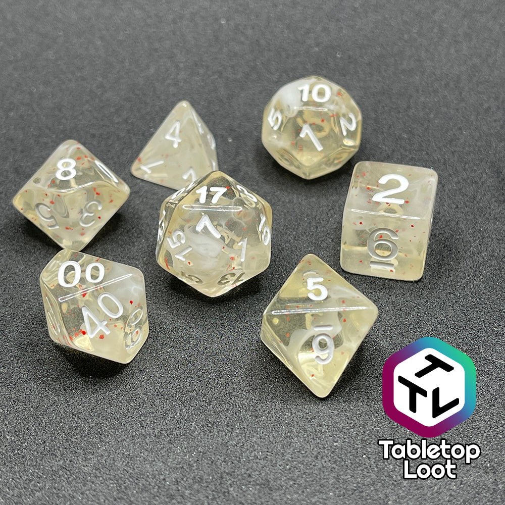 The Spore Cloud 7 piece dice set from Tabletop Loot with swirls of white and speckles of red suspended in clear resin and white numbering.