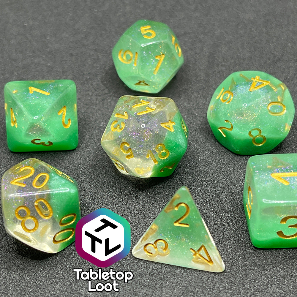 The Spring Dew 7 piece dice set from Tabletop Loot with a layer of shimmery light green under shimmery clear resin and gold numbering.