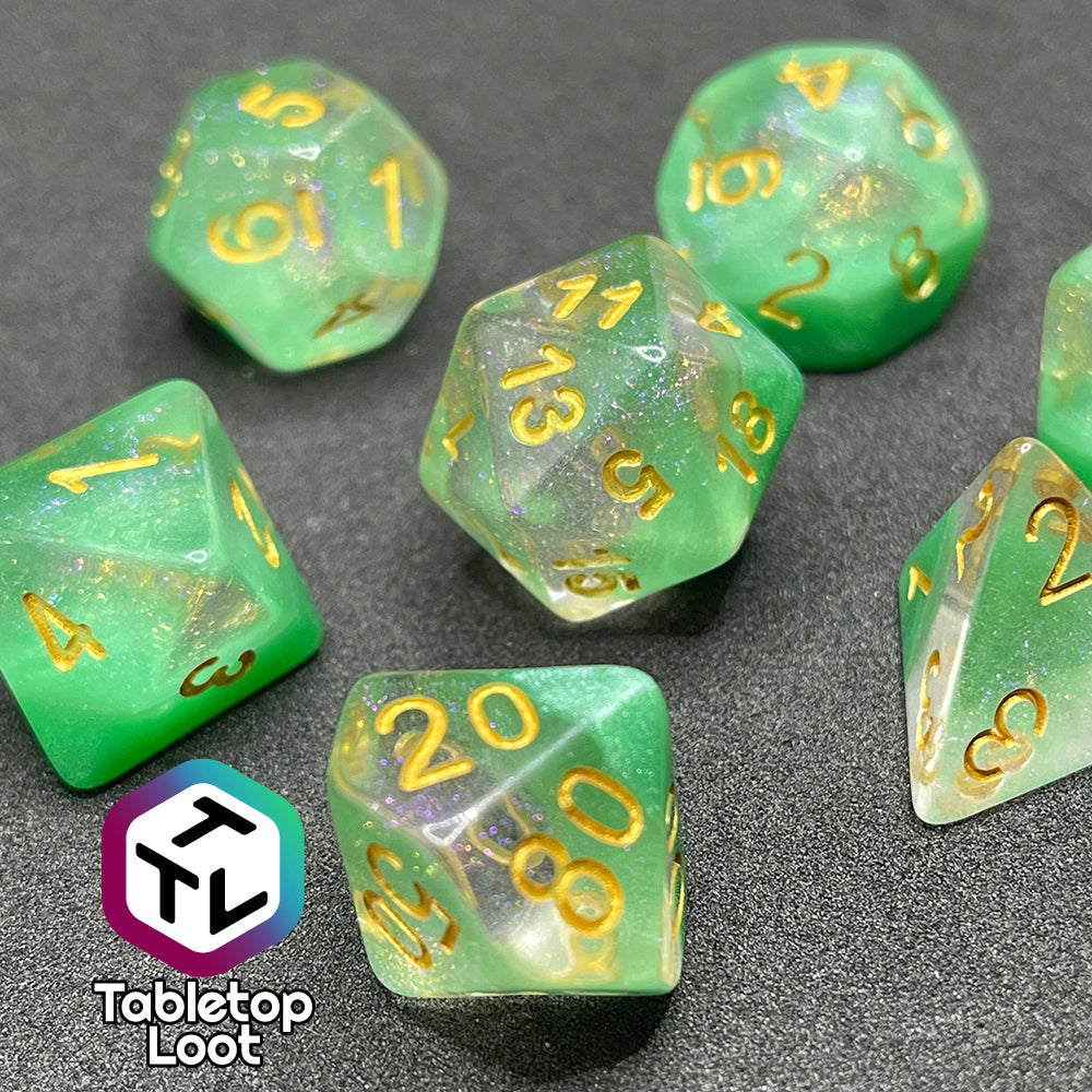 The Spring Dew 7 piece dice set from Tabletop Loot with a layer of shimmery light green under shimmery clear resin and gold numbering.