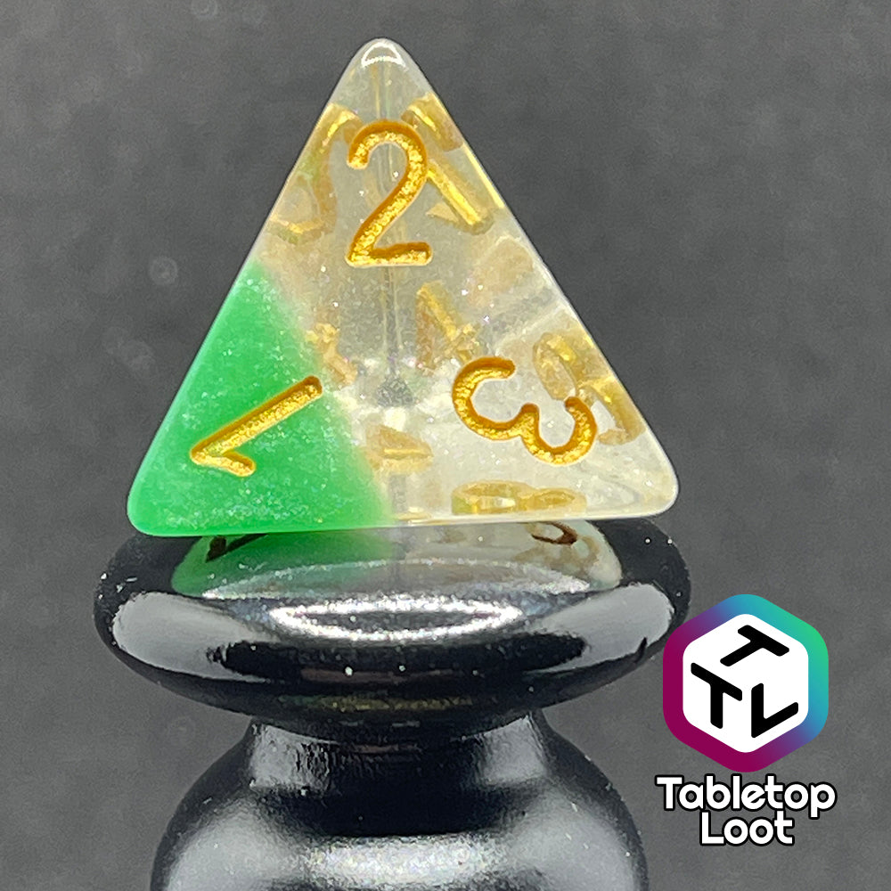 A close up of the D4 from the Spring Dew 7 piece dice set from Tabletop Loot with a layer of shimmery light green under shimmery clear resin and gold numbering.