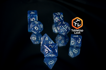 The Starry Form 7 piece dice set from Tabletop Loot packed with blue glitter and silver numbering.