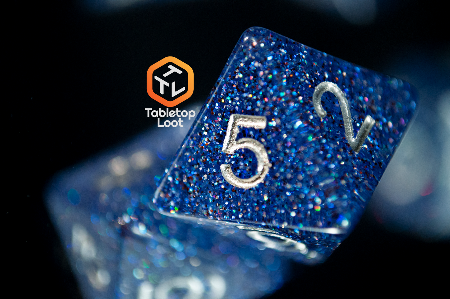 A close up of the D8 from the Starry Form 7 piece dice set from Tabletop Loot packed with blue glitter and silver numbering.
