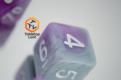 A close up of the D6 from the Stars Shine 7 piece dice set from Tabletop Loot with purple and grey shimmering swirls and white numbering.