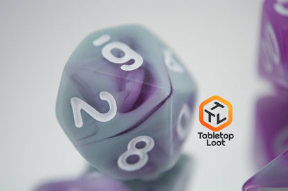 A close up of the D10 from the Stars Shine 7 piece dice set from Tabletop Loot with purple and grey shimmering swirls and white numbering.