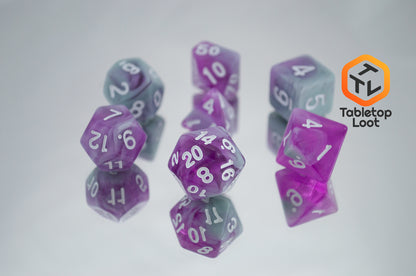 The Stars Shine 7 piece dice set from Tabletop Loot with purple and grey shimmering swirls and white numbering.
