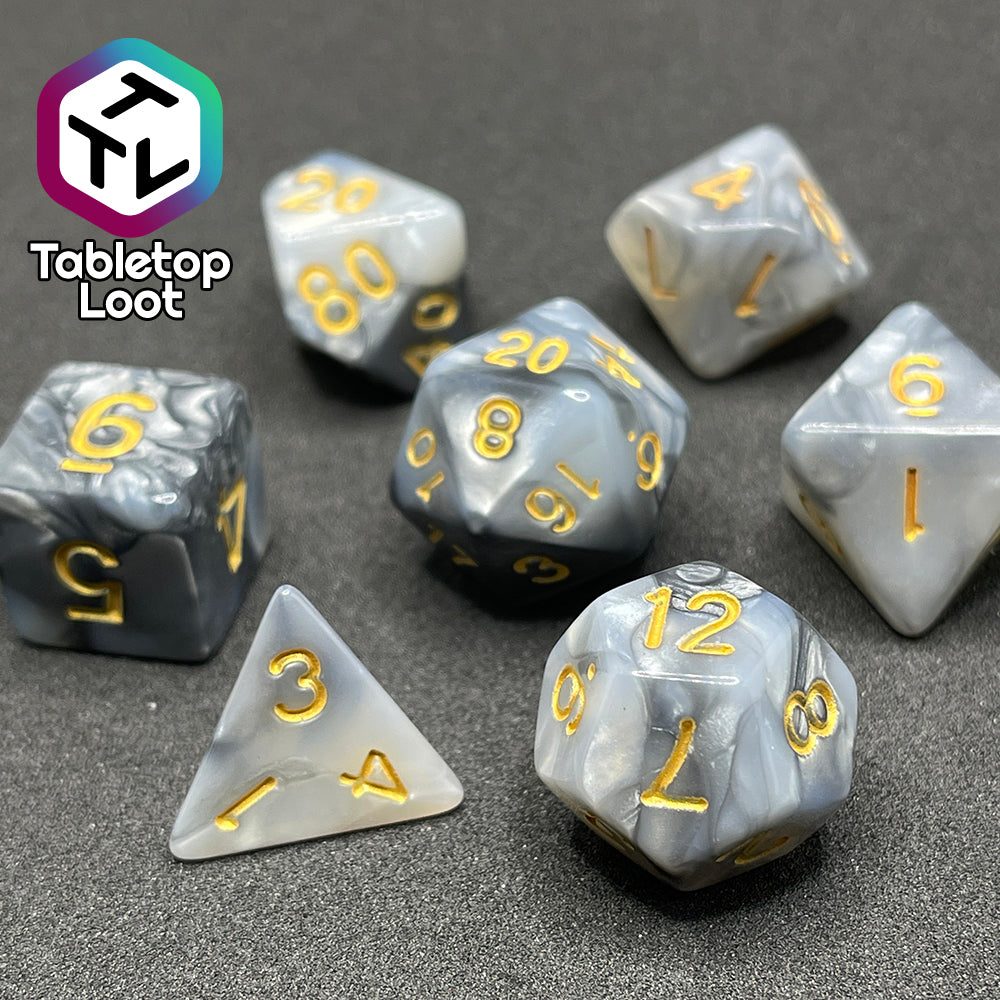 The Stone Giant 7 piece dice set with swirls of iridescent silver and white and gold numbering.