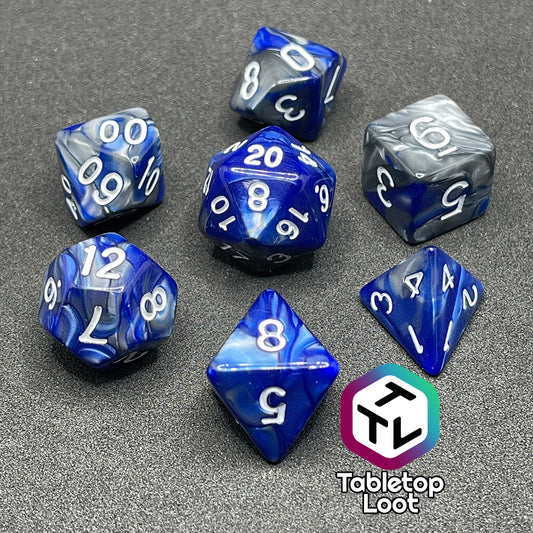 The Storm Giant 7 piece dice set from Tabletop Loot with swirls of pearlescent blue and silver and white numbering.