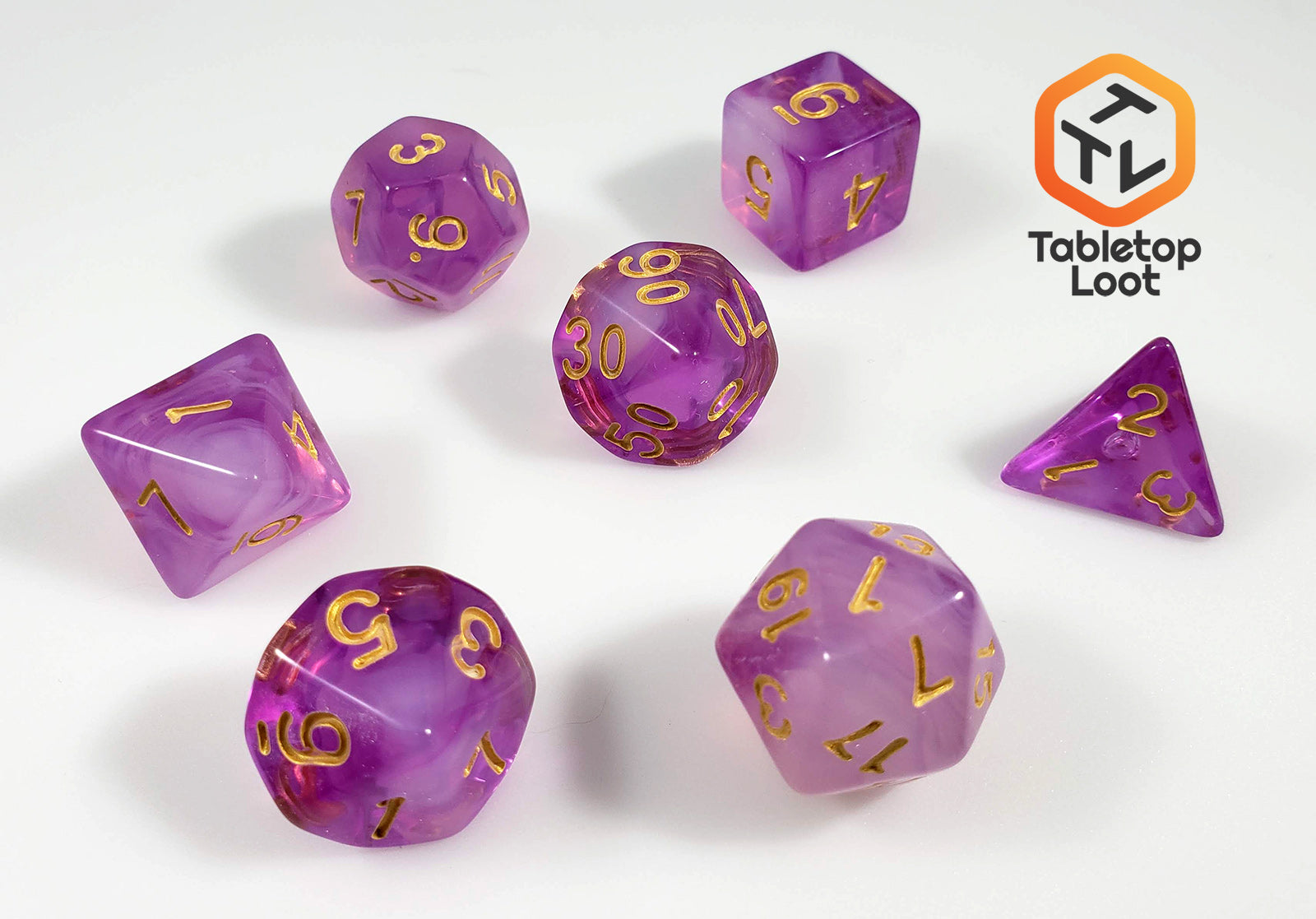 The Amethyst Geode 7 piece dice set from Tabletop Loot with swirls of purple and white resin and gold numbering.