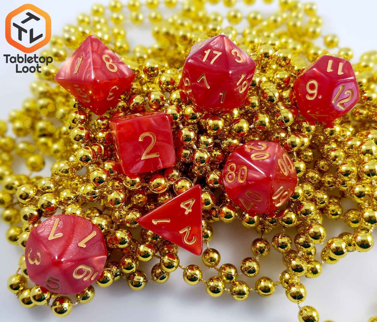 The Atomic Cinnamon 7 piece dice set from Tabletop Loot with swirls of red resin and gold numbering.
