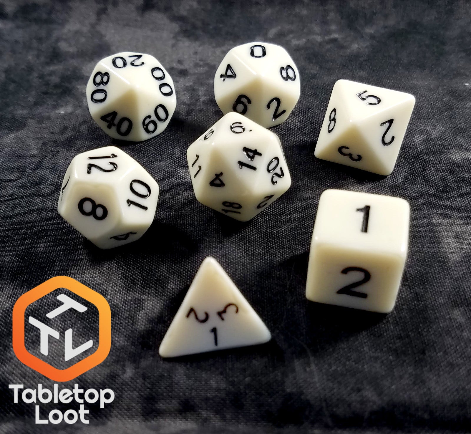 The Bleached Bone 7 piece dice set from Tabletop Loot with matte white resin and black numbering.