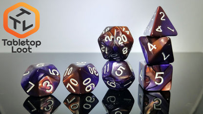The Cloud Nebula 7 piece dice set from Tabletop Loot with swirls of purple and bronze resin and white numbering.