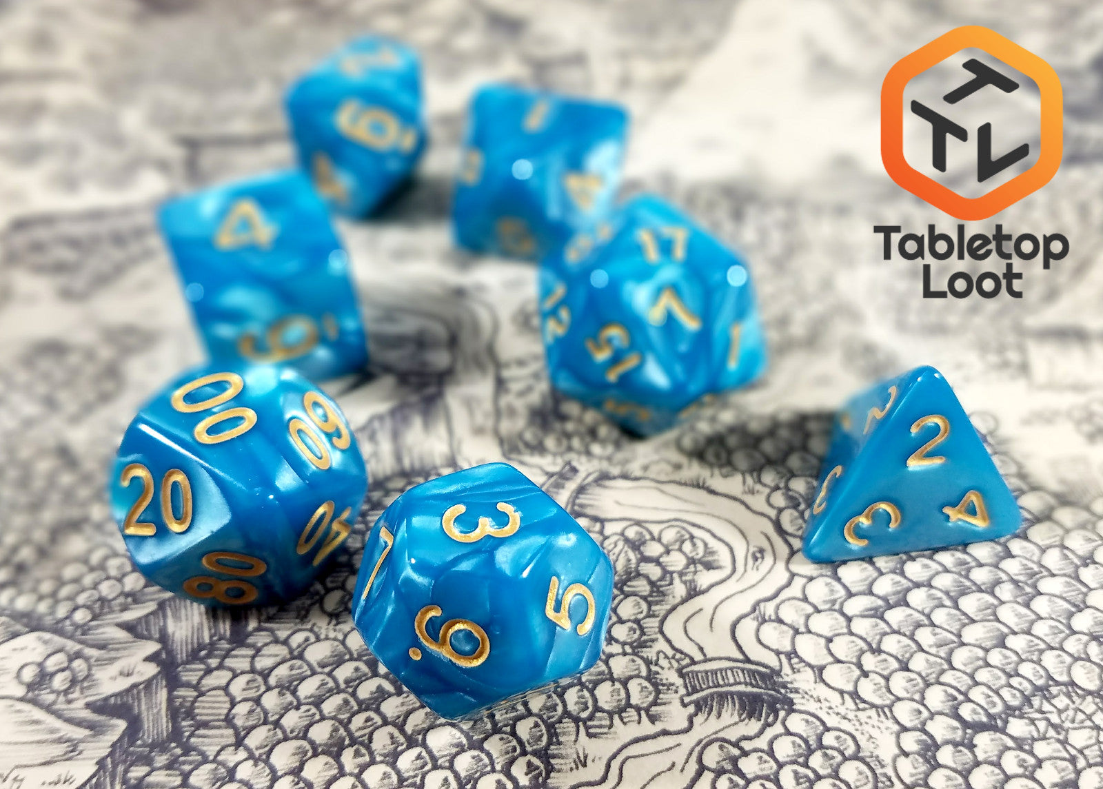 A close up of the Gilded Turquoise 7 piece dice set from Tabletop Loot with swirls of turquoise resin and gold numbering.