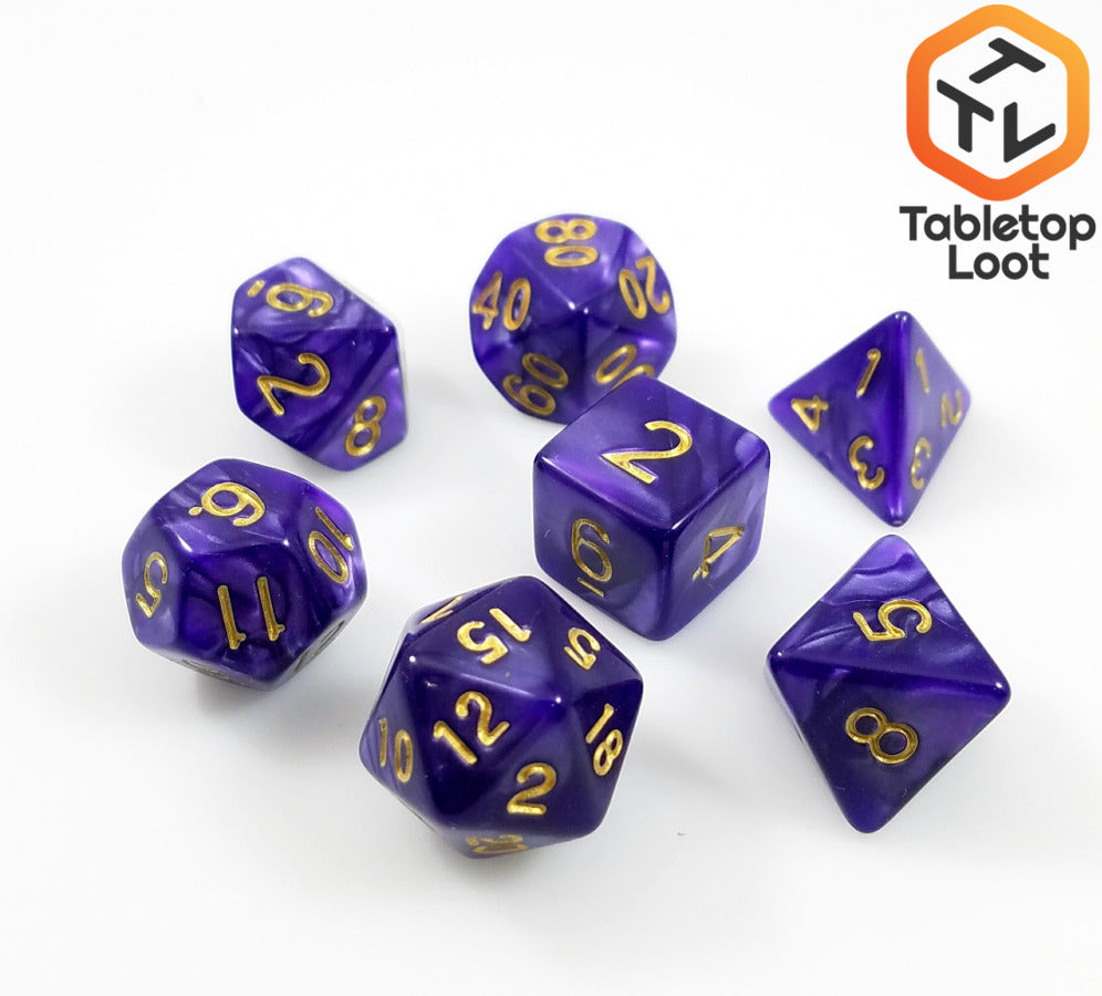 The Gilded Violet 7 piece dice set from Tabletop Loot with swirls of pearlescent purple resin and gold numbering.