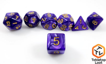 A close up of the D6 from the Gilded Violet 7 piece dice set from Tabletop Loot with swirls of pearlescent purple resin and gold numbering.