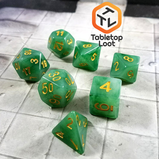 The Jade 7 piece dice set from Tabletop Loot with swirls of jade green and white resin and gold numbering.