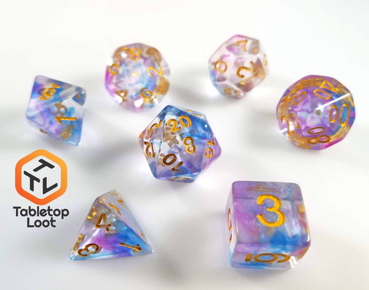 The Misty Step 7 piece dice set from Tabletop Loot with swirls of purple and blue in clear resin with gold numbers.