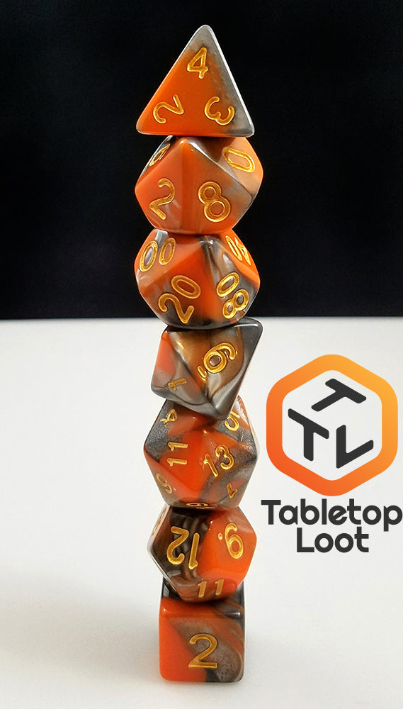 The Molten Steel 7 piece dice set from Tabletop Loot with swirling orange and silver resin and gold numbering.