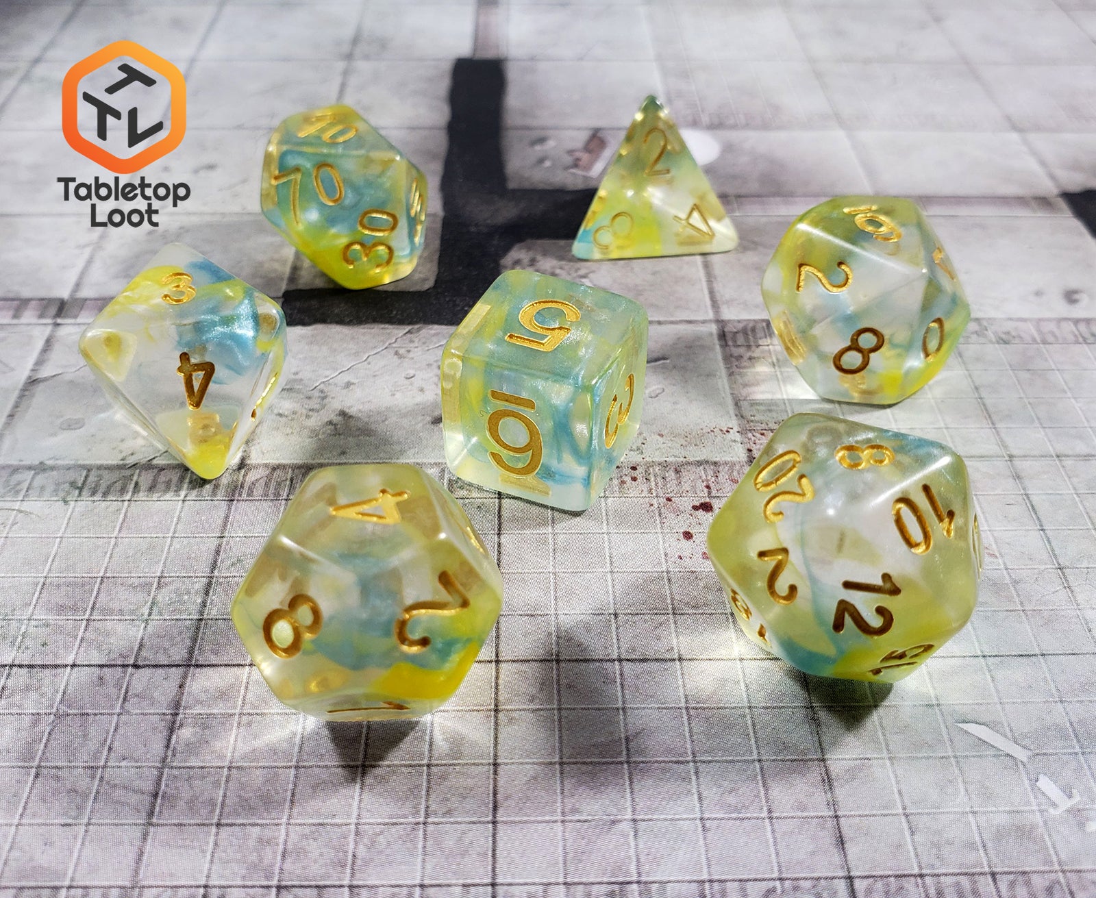 The Nature's Essence 7 piece dice set from Tabletop Loot with swirls of blue and green in clear resin with gold numbering.