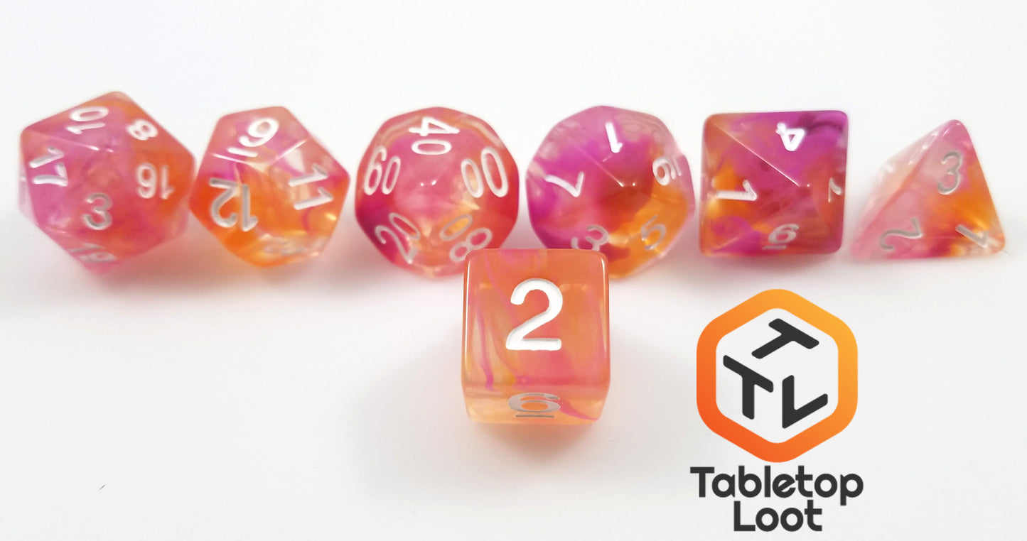A close up of the D6 from the Pink Lemonade 7 piece dice set from Tabletop Loot with swirls of pink, orange, and yellow in clear resin with white numbering.