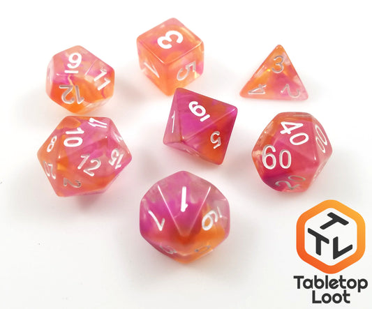 The Pink Lemonade 7 piece dice set from Tabletop Loot with swirls of pink, orange, and yellow in clear resin with white numbering.