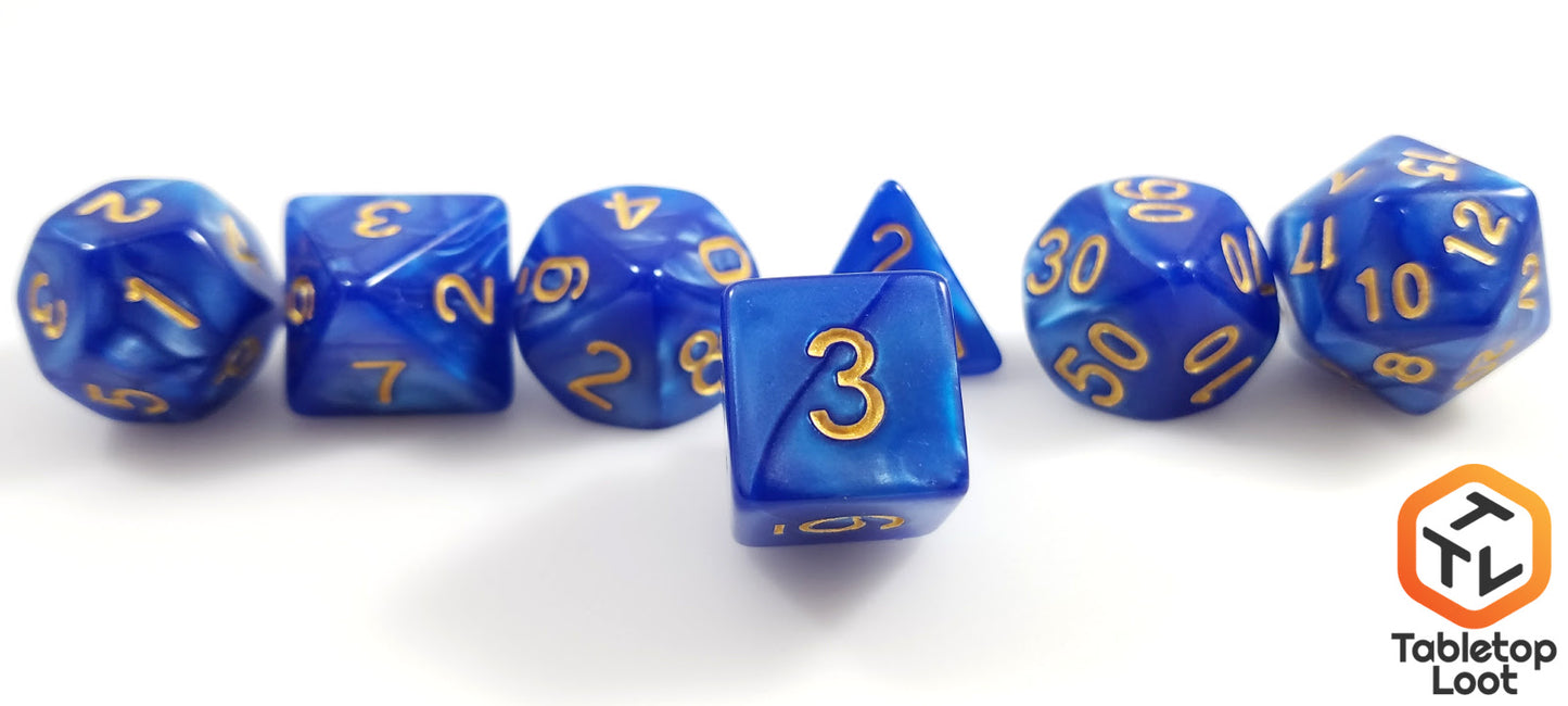 A close up of the D6 from the Royal Sapphire 7 piece dice set from Tabletop Loot with swirls of blue resin and gold numbering.