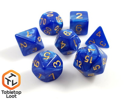 The Royal Sapphire 7 piece dice set from Tabletop Loot with swirls of blue resin and gold numbering.