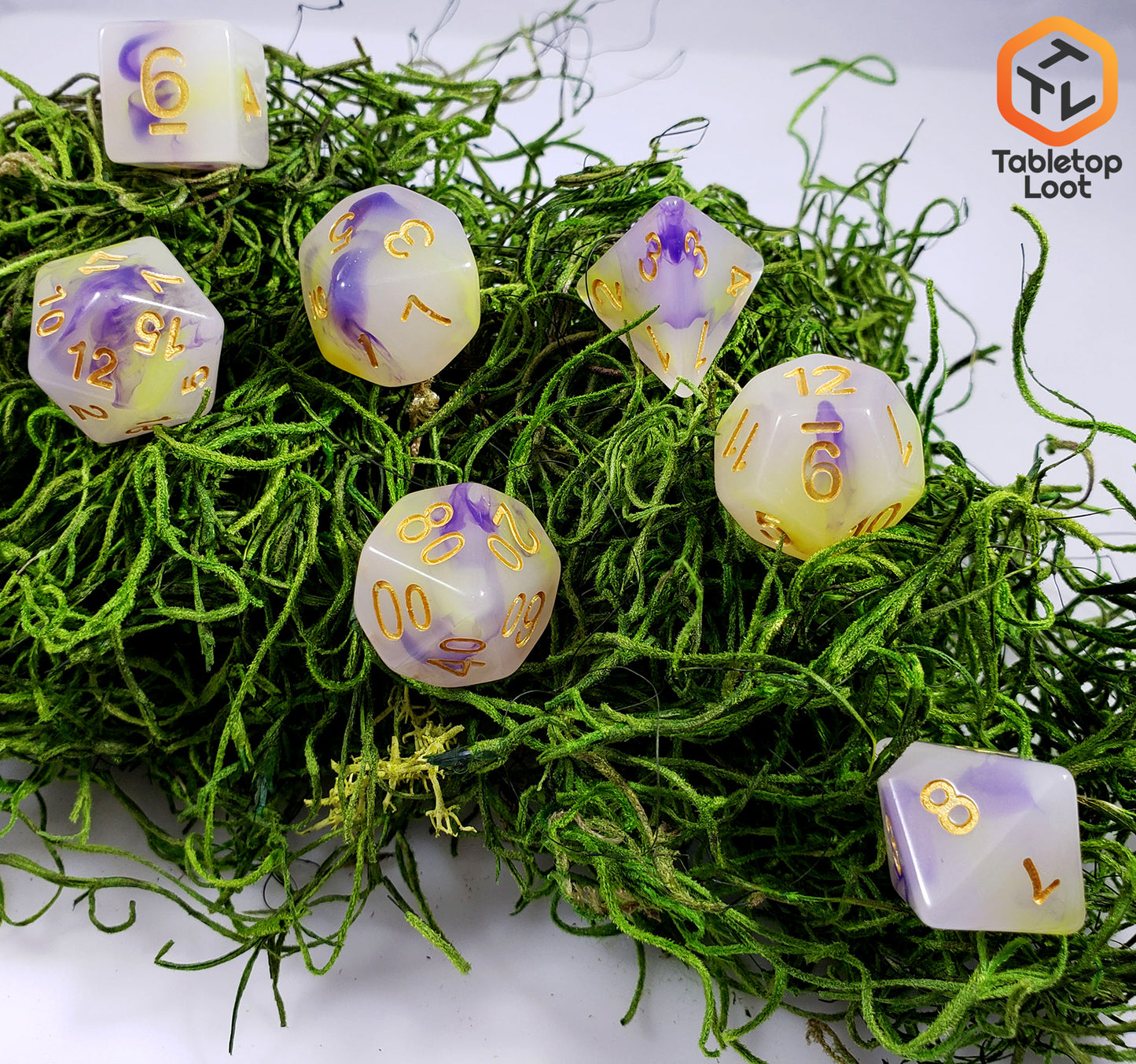 The Fields of Wildflowers 7 piece dice set from Tabletop Loot with swirls of purple and yellow in a milky resin and gold numbering.