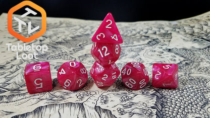 The Raspberry Tart 7 piece dice set with swirls of pearlescent pink and white numbering.