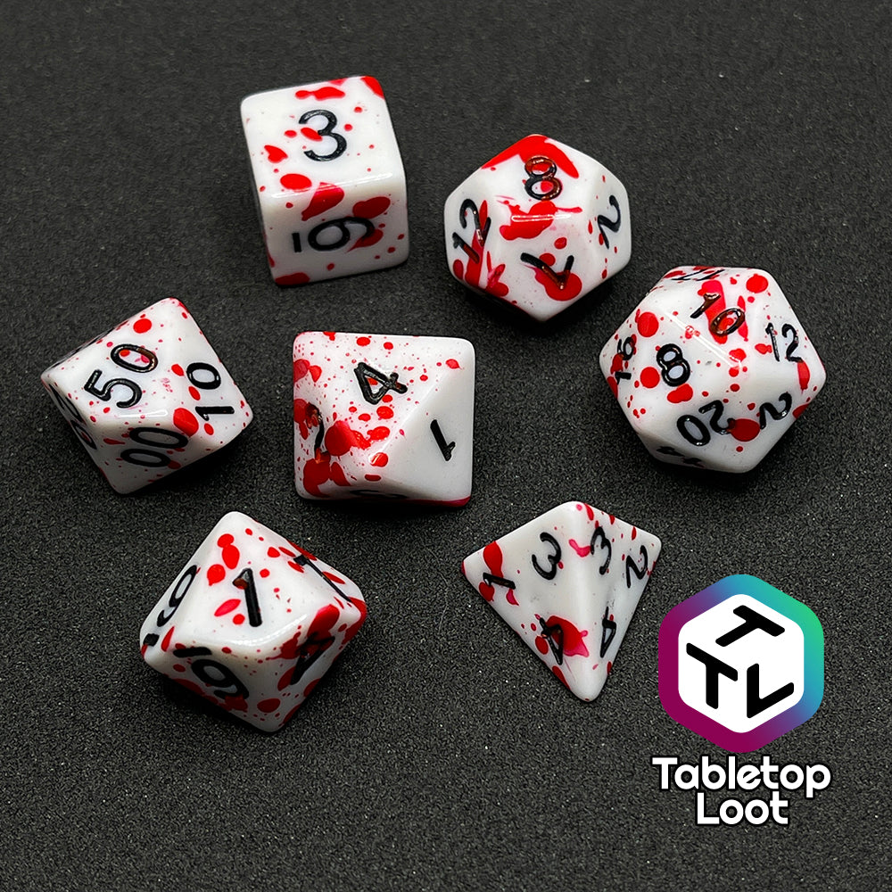The Tavern Brawl 7 piece dice set from Tabletop Loot; white dice with fake blood splatter and black numbering.
