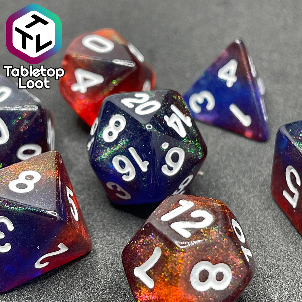 A close up of the Transmutation 7 piece dice set from Tabletop Loot with swirls of blue and red appearing purple in some spots, filled with iridescent glitter adding little rainbows in places, and inked in white.