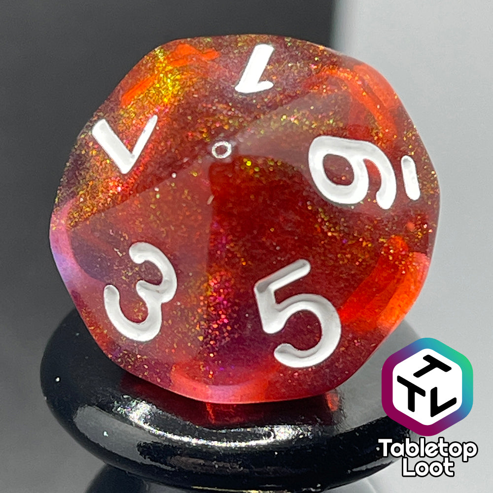 A close up of the D10 from the Transmutation 7 piece dice set from Tabletop Loot with swirls of blue and red appearing purple in some spots, filled with iridescent glitter adding little rainbows in places, and inked in white.