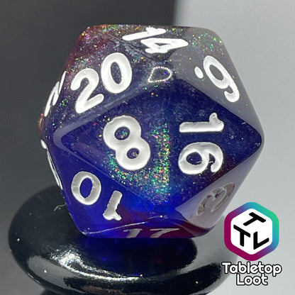 A close up of the D20 from the Transmutation 7 piece dice set from Tabletop Loot with swirls of blue and red appearing purple in some spots, filled with iridescent glitter adding little rainbows in places, and inked in white.