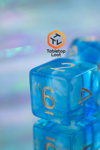 A close up of the D6 from the Under the Sea 7 piece dice set from Tabletop Loot with swirls of blue and gold numbering.